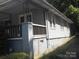 View of home showing exterior vinyl siding, brick foundation, and covered porch on side at 816 Parkwood Ave, Charlotte, NC 28205