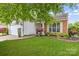 Well-maintained front yard with lush green grass and colorful landscaping leading to the home's entrance at 8410 Darcy Hopkins Dr, Charlotte, NC 28277