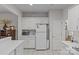 White kitchen featuring white cabinets, a white refrigerator, a microwave and white tile flooring at 8410 Darcy Hopkins Dr, Charlotte, NC 28277