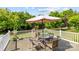 Outdoor patio featuring a table with chairs and an umbrella surrounded by lush greenery perfect for outdoor entertaining at 8410 Darcy Hopkins Dr, Charlotte, NC 28277