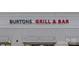 Exterior shot of Burton's Grill & Bar showcasing the restaurant's sign at 8410 Darcy Hopkins Dr, Charlotte, NC 28277
