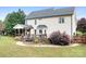 A view of the backyard, featuring a wooden deck attached to the house, surrounded by green grass at 9000 Petunia Ct, Gastonia, NC 28056