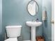 Powder room with pedestal sink, decorative mirror, and coordinating blue walls at 9000 Petunia Ct, Gastonia, NC 28056