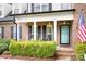 Covered front porch with blue door and decorative shrubs for enhanced curb appeal at 9000 Petunia Ct, Gastonia, NC 28056