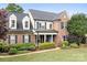 Traditional two-story brick home with well-manicured lawn and patriotic American flag at 9000 Petunia Ct, Gastonia, NC 28056
