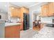 Open kitchen view showcases wood cabinets, granite countertops, stainless steel fridge, and eat-in nook at 9000 Petunia Ct, Gastonia, NC 28056
