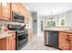 Kitchen with stainless steel appliances, wood cabinets, granite counters, and tile floors at 9000 Petunia Ct, Gastonia, NC 28056
