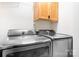 Modern laundry room with stainless steel Samsung washer and dryer and white upper cabinet at 9000 Petunia Ct, Gastonia, NC 28056