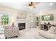 Bright living room featuring a fireplace, ceiling fan, and access to the outdoors at 9000 Petunia Ct, Gastonia, NC 28056