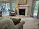 Comfortable living room with a fireplace, neutral carpet, and a cozy armchair at 9000 Petunia Ct, Gastonia, NC 28056