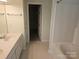 Bright bathroom featuring double sinks, white cabinetry, tile flooring, and access to a walk-in closet at 9237 Bellegarde Dr, Charlotte, NC 28277