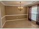 Traditional dining room with chandelier, trim, large window, and neutral wall paint at 9237 Bellegarde Dr, Charlotte, NC 28277