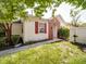 This exterior view shows the side yard, red shutters, brick detail, and well-maintained landscaping at 9360 Meadowmont View Dr, Charlotte, NC 28269