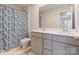 Modern bathroom with double sinks, grey cabinets, a stylish shower curtain and neutral wall color at 1001 Linn Cv, Waxhaw, NC 28173