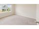 Bright bedroom featuring a large window letting in natural light, neutral walls, and plush carpeting at 1001 Linn Cv, Waxhaw, NC 28173