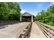 A covered bridge with metal supports along a rural road with green foliage at 1001 Linn Cv, Waxhaw, NC 28173