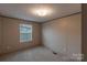 Inviting bedroom features carpeted flooring, a window with blinds, and neutral-toned walls, creating a peaceful retreat at 105 Peridot Dr, Statesville, NC 28625