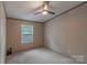Neutral bedroom featuring a window, a ceiling fan and carpet flooring, creating a calm and inviting space at 105 Peridot Dr, Statesville, NC 28625