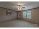 Cozy living room featuring neutral carpet, ceiling fan, and natural light from windows at 105 Peridot Dr, Statesville, NC 28625