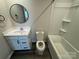 Bathroom features a modern vanity, round mirror, and shower-tub combination at 110 Browband St, Troutman, NC 28166
