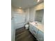 Bright bathroom featuring a shower-tub combo and a sink with white cabinets at 110 Browband St, Troutman, NC 28166