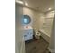 Bathroom features a modern vanity, round mirror, and shower-tub combination at 110 Browband St, Troutman, NC 28166