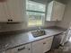 Granite countertops, undermount sink, and stainless steel dishwasher, plus a view of the backyard at 110 Browband St, Troutman, NC 28166