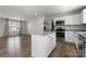 Open concept kitchen with island, stainless steel appliances, and hardwood floors at 110 Browband St, Troutman, NC 28166