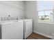 Well-lit laundry room with window includes a washer and dryer at 110 Browband St, Troutman, NC 28166