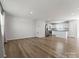 Open-concept living area with hardwood floors, recessed lighting, and a view into the modern white kitchen at 110 Browband St, Troutman, NC 28166