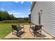 Cozy patio with chairs overlooking the green backyard with a wooded fence line at 110 Browband St, Troutman, NC 28166
