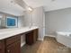 Bathroom featuring a double vanity, soaking tub, and a large mirror at 110 Colville Rd, Mooresville, NC 28117