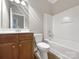 Bathroom with a single vanity, toilet, and shower-tub combination with white tile surround at 110 Colville Rd, Mooresville, NC 28117