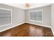 Well-lit bedroom with hardwood flooring, a ceiling fan, and two windows at 110 Colville Rd, Mooresville, NC 28117