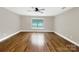 A bright bedroom showcases hardwood floors, a ceiling fan, and a window at 110 Colville Rd, Mooresville, NC 28117