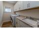 Functional laundry room with washer, dryer, sink, countertop, and ample cabinet space at 1109 Bunch Dr, Statesville, NC 28677