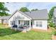 Well-maintained rear exterior of the home featuring a covered patio, lush lawn and mature trees at 1109 Bunch Dr, Statesville, NC 28677