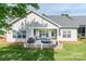 Well-maintained rear exterior featuring a covered patio with grill, lush lawn and mature trees at 1109 Bunch Dr, Statesville, NC 28677