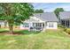 Rear exterior featuring a covered patio, lush lawn, mature trees, and an inviting outdoor space at 1109 Bunch Dr, Statesville, NC 28677