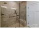 Luxurious tiled shower with glass door, rainfall shower head, bench, and built-in niche at 1109 Bunch Dr, Statesville, NC 28677