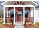 Inviting front porch with red siding, white trim, and decorative railing, enhancing the curb appeal of this lovely home at 1244 Bob Falls Rd, Shelby, NC 28150