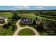 Stunning aerial view of a home with a circular driveway, lush green lawns, and a backdrop of rolling hills and forest at 129 Renaissance Pl, Statesville, NC 28625