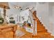 Open-concept living room with hardwood floors, a fireplace, and staircase at 129 Renaissance Pl, Statesville, NC 28625