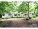 Modest single-story home featuring a lush, tree-filled yard and vinyl siding at 1320 Smith Woods Dr, Hickory Grove, SC 29717