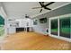 Wood-floored back porch with a TV, fan, and white railing overlooking the expansive backyard at 138 Montibello Dr, Mooresville, NC 28117