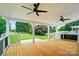 Covered back porch with wood floors, ceiling fans, and views of the expansive yard and lush landscaping at 138 Montibello Dr, Mooresville, NC 28117