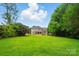 A well-maintained backyard featuring lush green grass and a gray house with a covered porch at 138 Montibello Dr, Mooresville, NC 28117