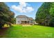 Expansive backyard showcasing a gray house, covered porch, and lush green lawn, perfect for outdoor activities at 138 Montibello Dr, Mooresville, NC 28117