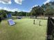 Community dog park with blue play structures on a green artificial turf surface surrounded by fencing at 138 Montibello Dr, Mooresville, NC 28117