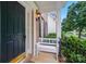 Cozy front porch featuring a classic black door, white bench, and wrought iron railing at 138 Montibello Dr, Mooresville, NC 28117